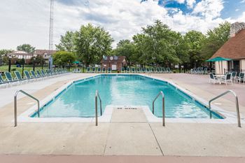 a resort style swimming pool with chaise lounge chairs and trees in the background  at Pheasant Run, Indiana, 47909